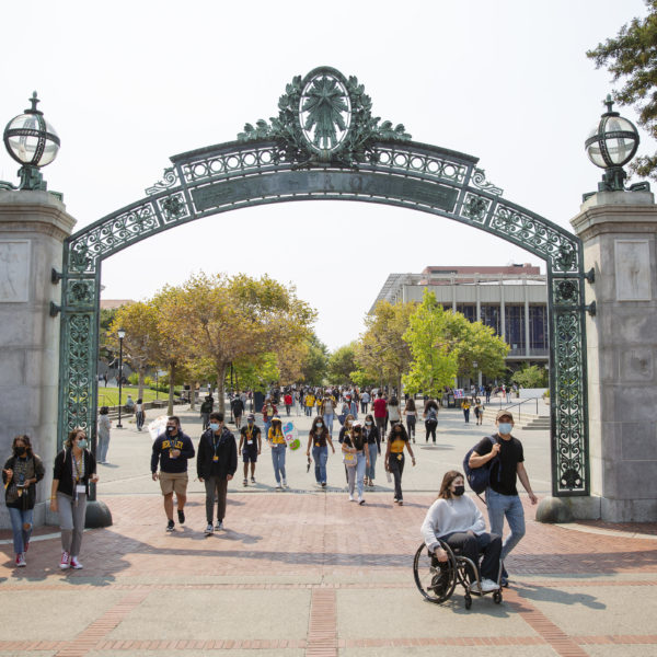 photo of student first day on campus walking under sather gate.