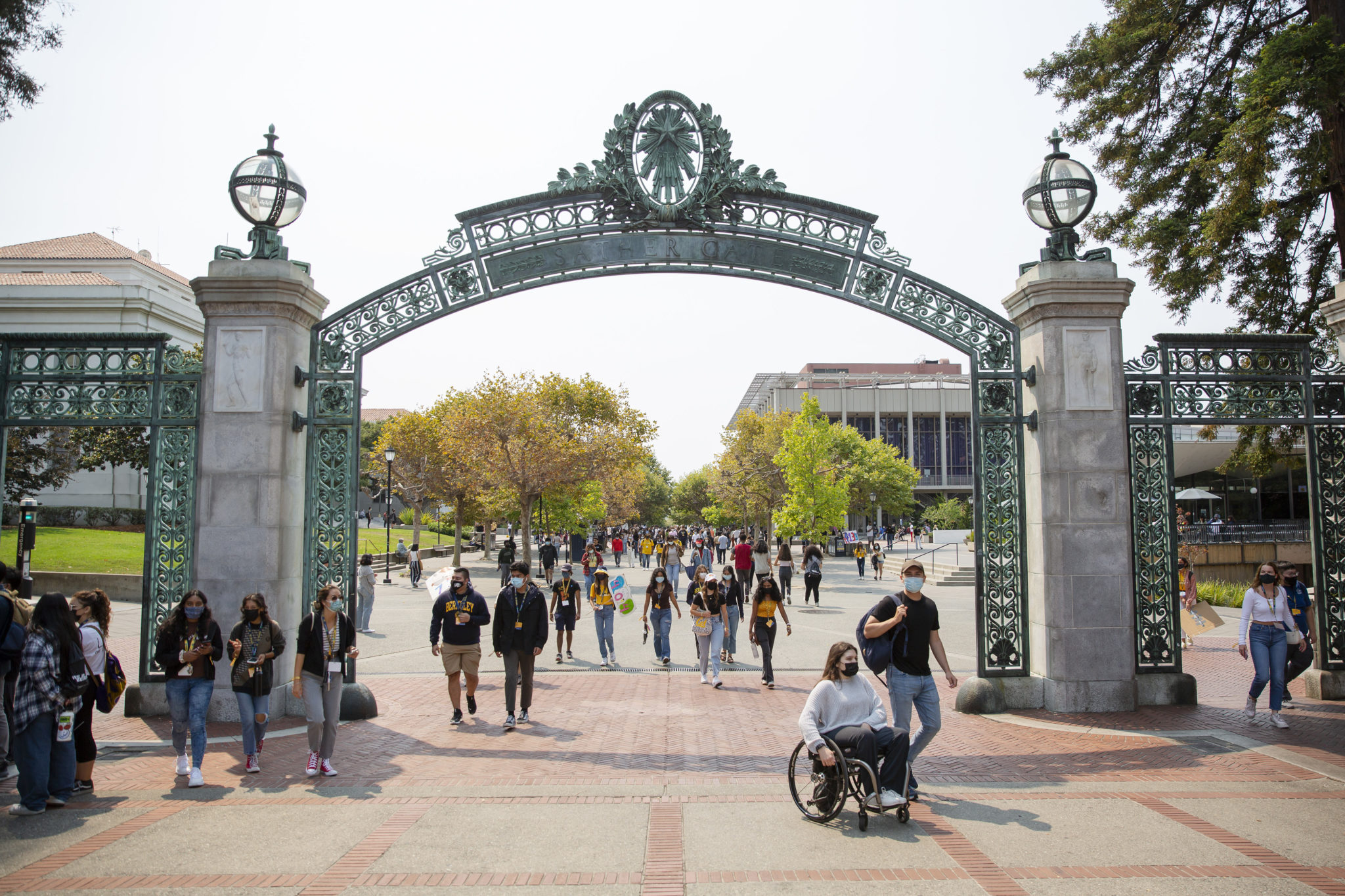 photo of student first day on campus walking under sather gate.