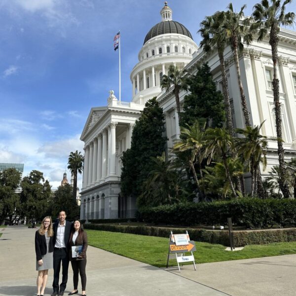 Group of individuals standing next to California's capital building