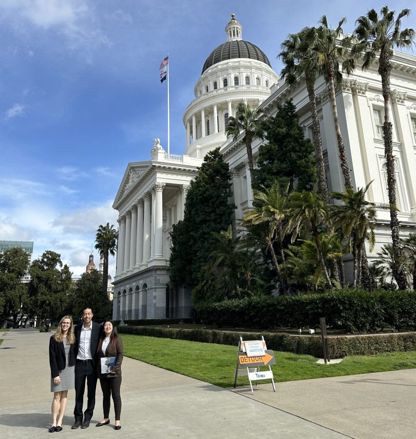 Group of individuals standing next to California's capital building