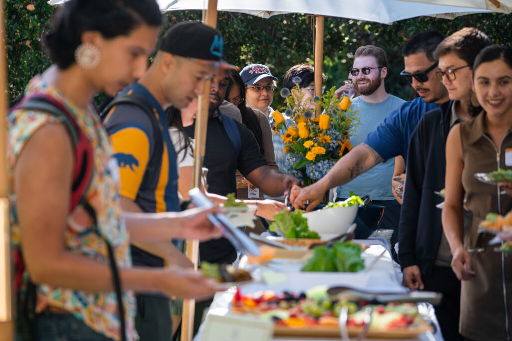 People getting food from the table of food