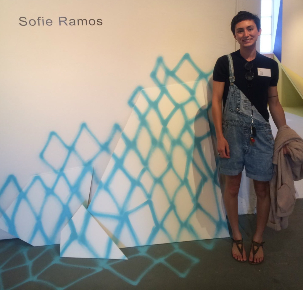 Photo of Sofie Ramos next to artwork