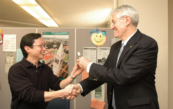 Charles Tung receives a ceremonial lollipop and the congratulations of Chancellor Birgeneau after filing his doctoral dissertation in the Graduate Degrees Office.