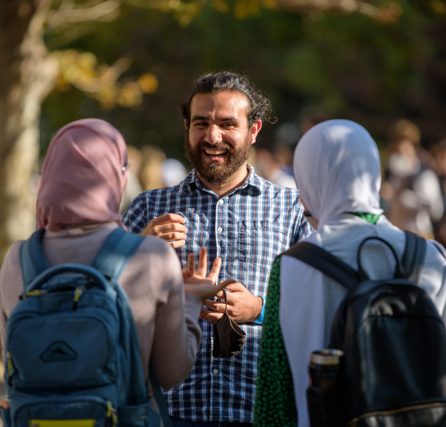 student talking to other students wearing hijabs