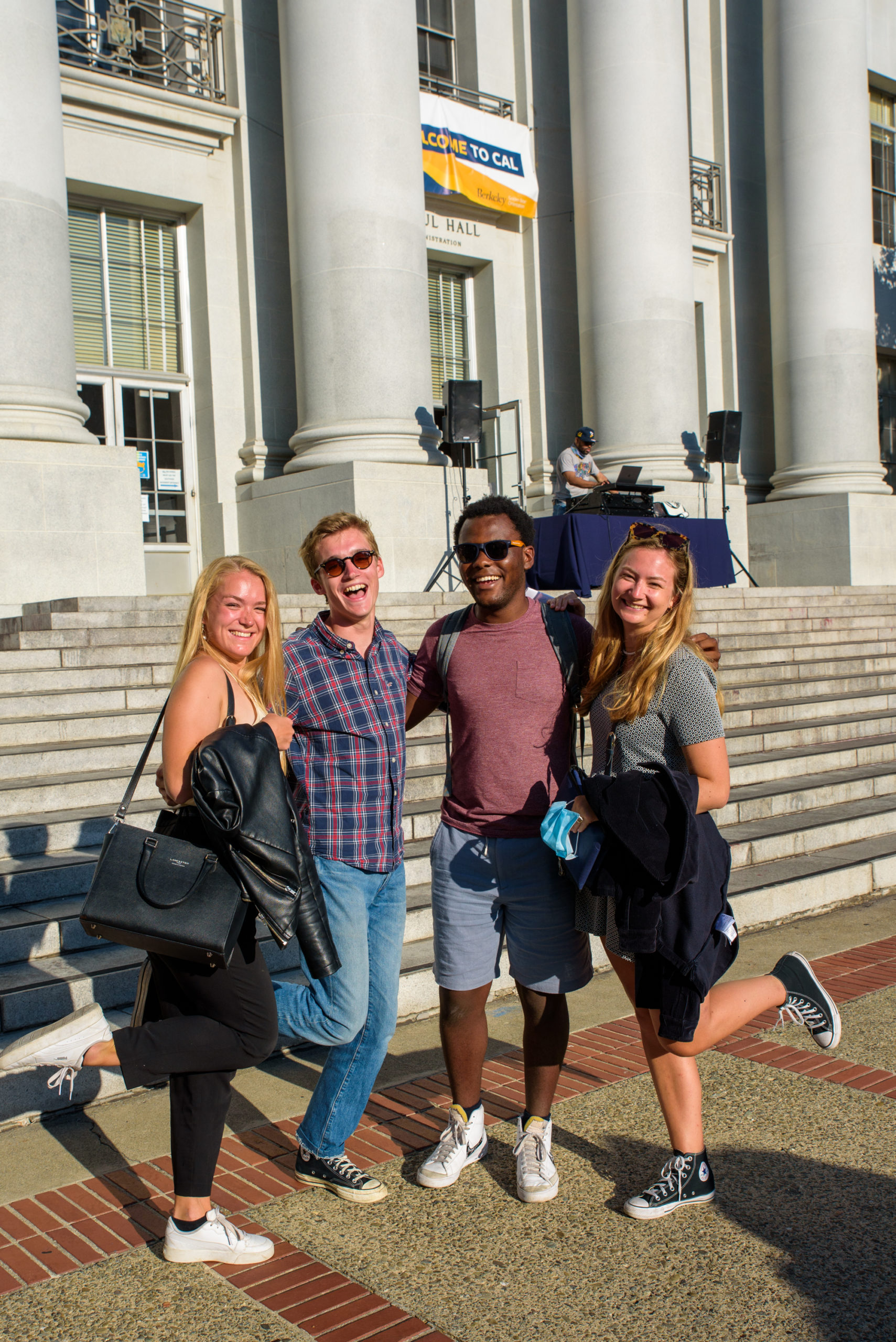 Four students pose together on the steps of Sproul Hall.