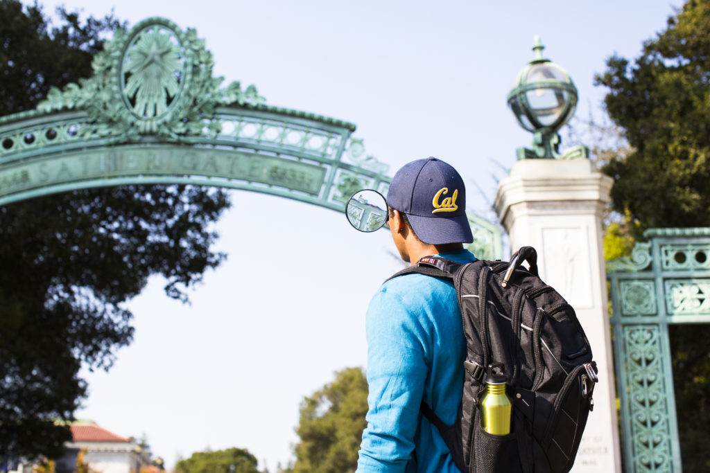student looking at Sather Gate with a magnifying glass