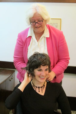 Sarah Cowan is adorned with Una's necklace by Rosemary Joyce, Graduate Division associate dean. (photo: Ellen Gobler)