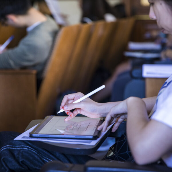 student writing on a tablet