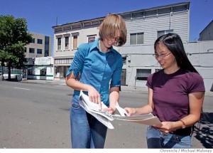 Before demolition: Anna Naruta and Kelly Fong near a storefront remnant of Oakland's early Chinatown. A few months later, it was gone, along with its neighbors.