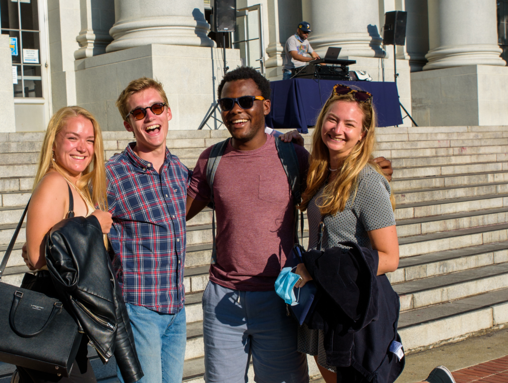 four graduate students posing in front of Sproul Hall steps