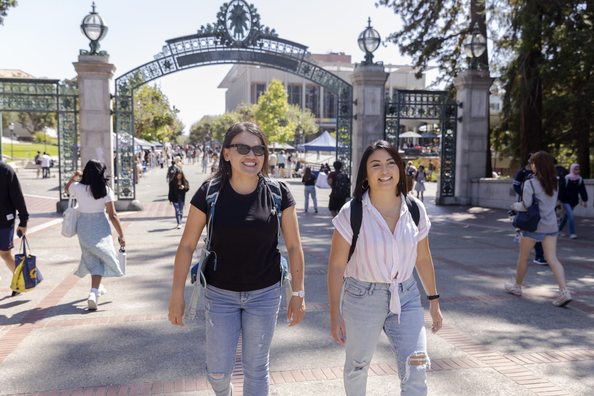 2 students walking under sather gate