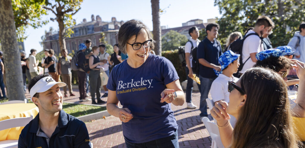 VP for graduate studies Lisa Garcia Bedolla chatting with 2 students at grad-stravaganza